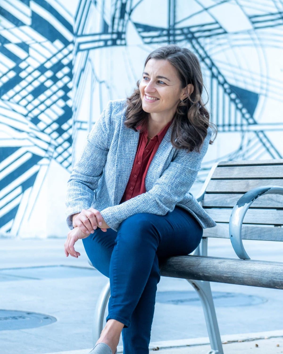 Karen Knab seated on a bench, smiling and looking off to the side